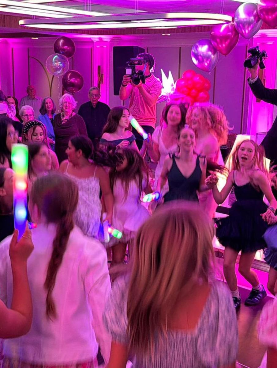 Guests dancing under pink lights and balloons at a Bat Mitzvah planned by Heather at the Renaissance Charlotte SouthPark